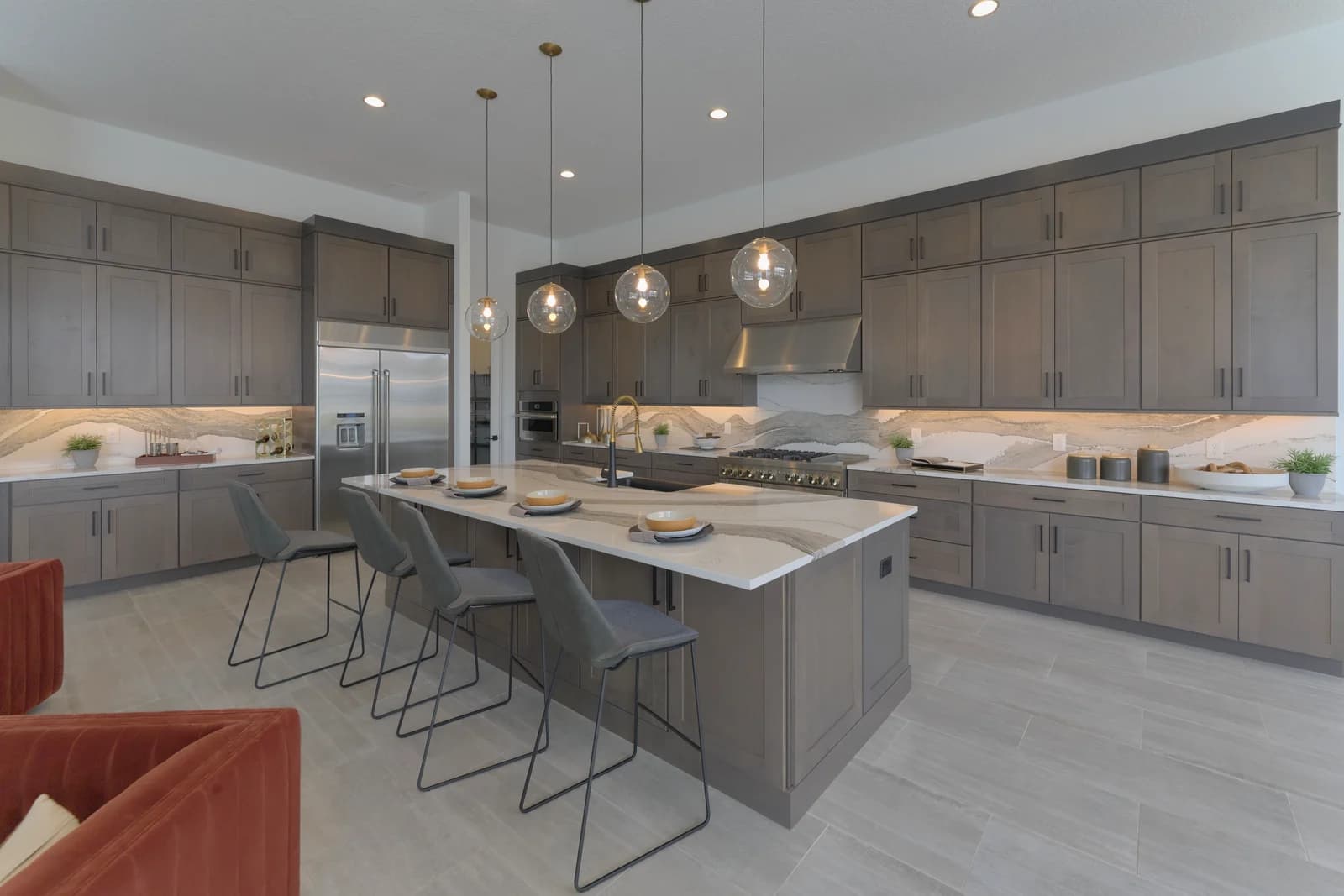 Designer kitchen with floor-to-ceiling wood cabinetry, a quartz waterfall island, and globe pendant lights